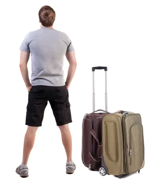 男探しているスーツケースと一緒に旅行の背面図. — ストック写真