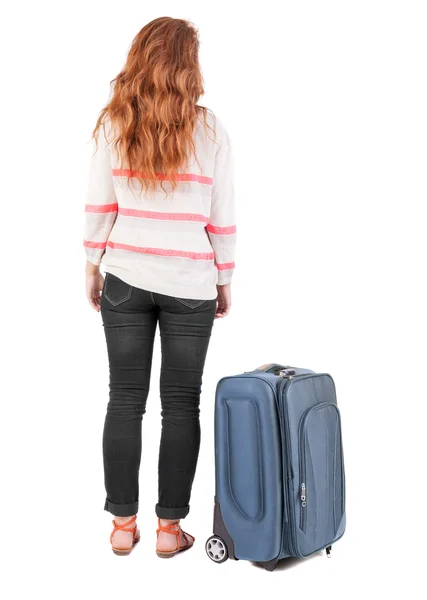Назад точка зрения идущей женщины с чемоданом. — стоковое фото