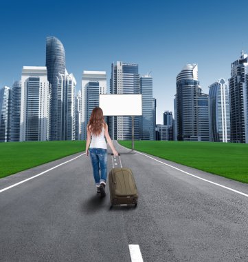 Şehir, boş bir reklam panoları önünde giden yolda yürüyen kadın.