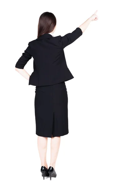 Bakifrån av ung brunett affärskvinna pekar på väggen. — Stockfoto