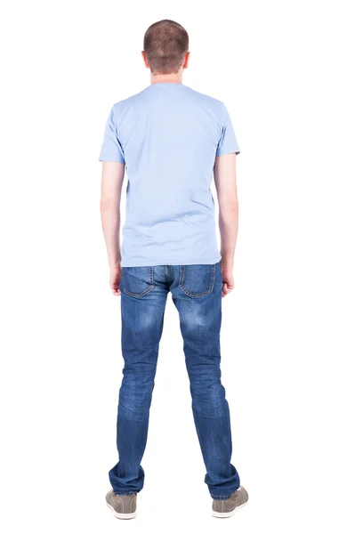 Back view of young man in t-shirt and jeans looking. — Stock Photo, Image