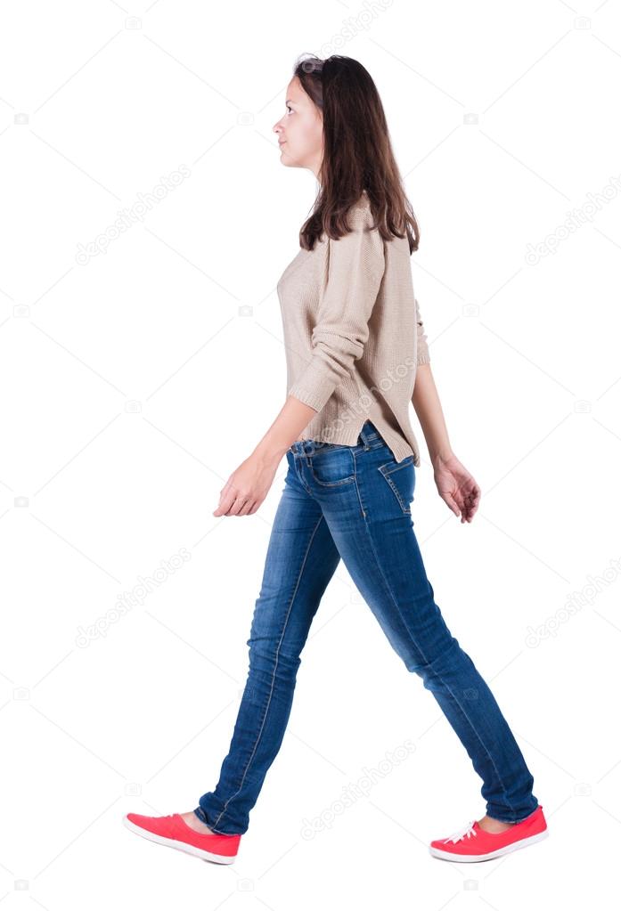 back view of walking woman in jeans .