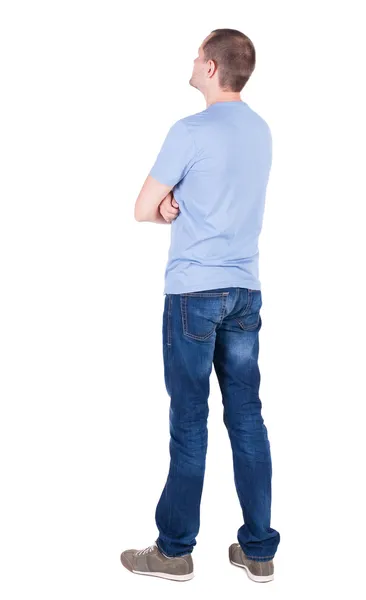 Achteraanzicht van jonge man in t-shirt en jeans op zoek. — Stockfoto