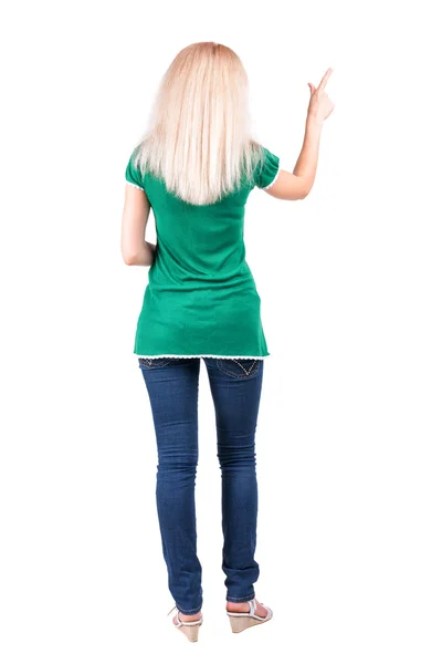 Achteraanzicht van jonge blonde vrouw wijzend op de muur. — Stockfoto