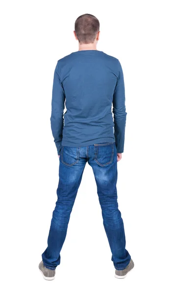 Back view of young man in t-shirt and jeans looking — Stock Photo, Image