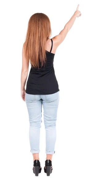 Vista di puntamento donna posteriore. ragazza bella rossa in jeans. — Foto Stock