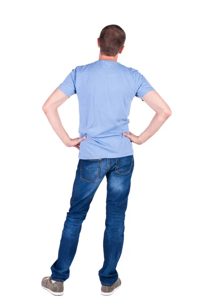 Вид ззаду молодого чоловіка в футболці і джинсах дивиться . — стокове фото