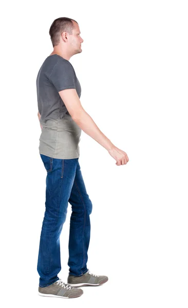 Achteraanzicht van gaan knappe man in spijkerbroek en een shirt. — Stockfoto