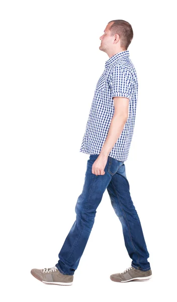 Bakifrån gå stilig man i jeans och en skjorta. — Stockfoto