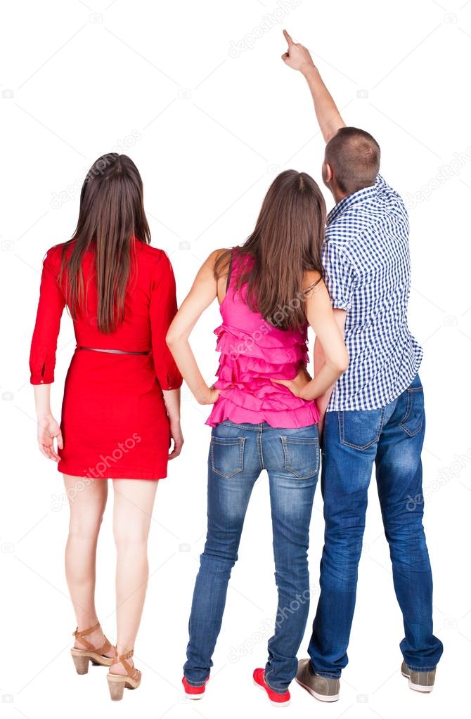 Back view of three friends. pointing man and two women looking.
