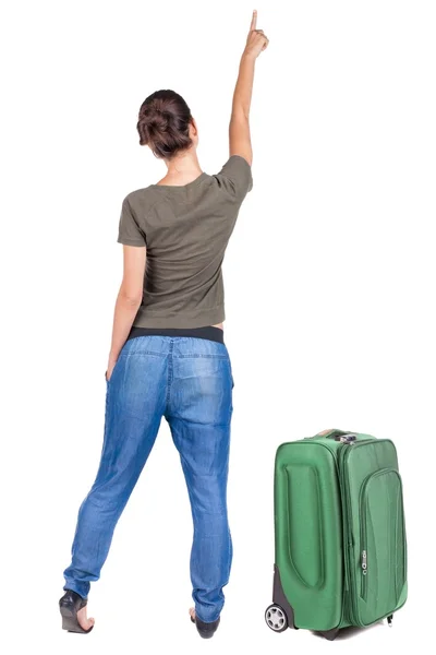 Back view of traveling pointing woman with suitcase. — Stock Photo, Image