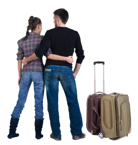 Young traveling couple with suitcas looks where that – stockfoto
