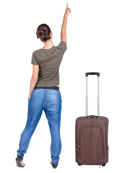 Rückansicht des traveling zeigenden weiblich mit Koffer. — Stockfoto