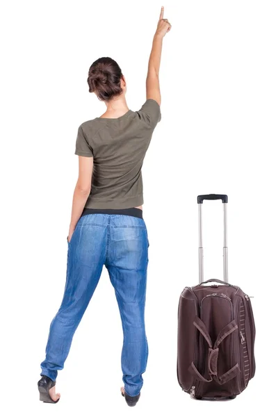 Back view of traveling pointing woman with suitcase. — Stock Photo, Image