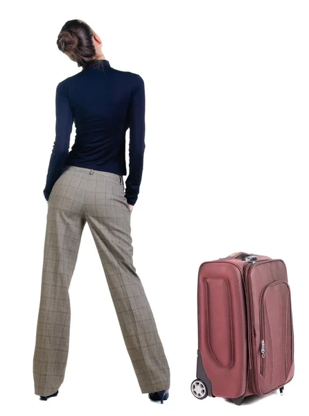 Traveling young woman with suitcas looking at wall. — Stock Photo, Image