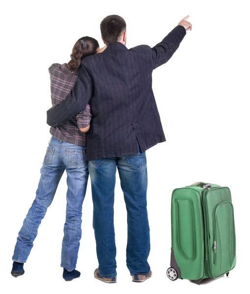 Ταξιδεύουν νεαρό ζευγάρι με suitcas που δείχνει σε τοίχο. οπίσθια όψη — Φωτογραφία Αρχείου