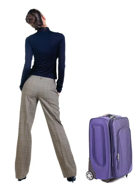 Reisen junge Frau mit Suitcas Blick auf Wand. — Stockfoto