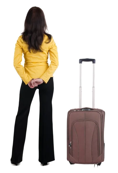Jonge vrouw met suitcas in gele pak muur kijken reizen — Stockfoto