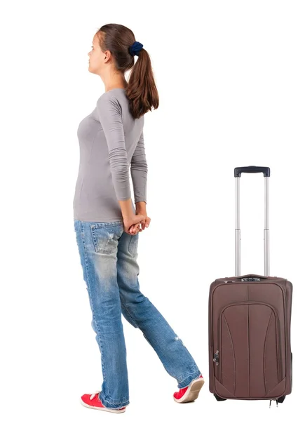 Pohled zezadu na stojící mladá bruneta žena s kufrem na cestách — Stock fotografie