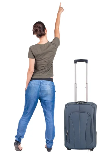 Arkadan görünüşü ile bavul seyahat işaret eden kadın. — Stok fotoğraf
