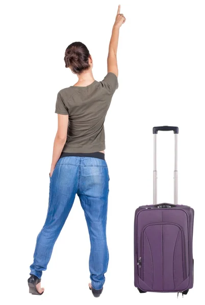 Back view of traveling pointing woman with suitcase. — Stock Photo, Image