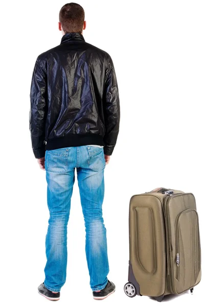 Back view of traveling handsome man in jacket with suitcas look — Stock Photo, Image
