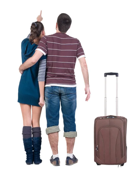 Jonge reizende paar met suitcas ziet er waar dat. — Stockfoto