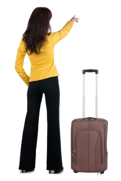Молода подорожуюча жінка з точками валізи на стіні . — стокове фото