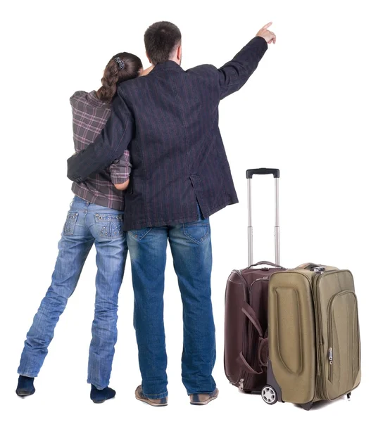 Jovem casal a viajar com suitcas apontando para a parede. vista traseira — Fotografia de Stock