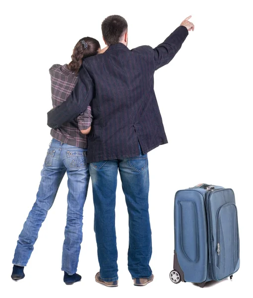 壁を指して suitcas 連れの若いカップル。背面図 — ストック写真