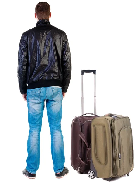 Vista posterior de hombre guapo en chaqueta con mirada de maleta de viaje —  Fotos de Stock