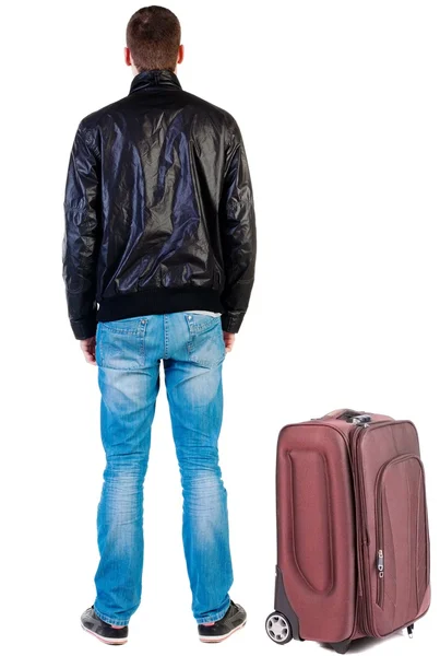 Back view of traveling handsome man in jacket with suitcas look — Stock Photo, Image