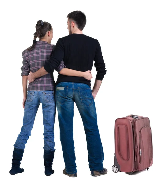 Young traveling couple with suitcas looks where that – stockfoto