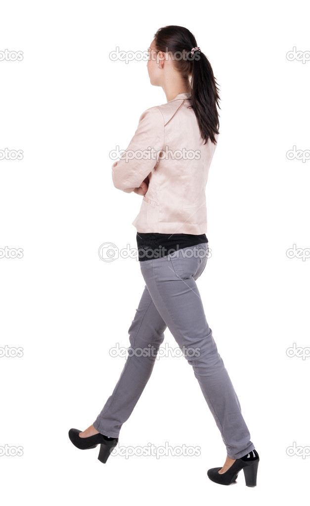 back view of walking woman in jeans