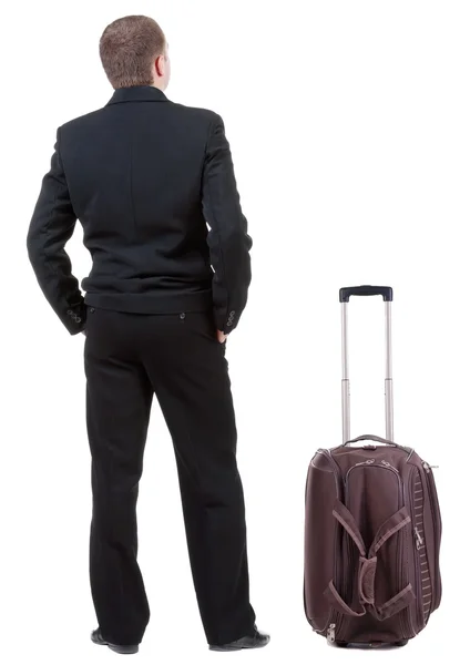 Mężczyzna w czarnym garniturze podróży z suitcas — Zdjęcie stockowe