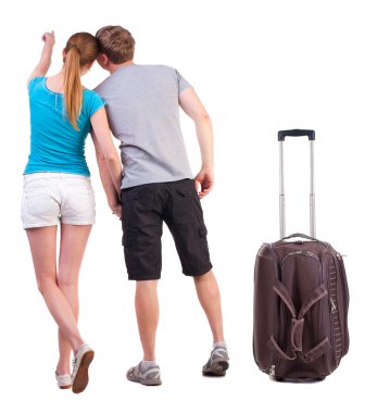 Genç çift suitcas ile seyahat ve duvara dönük