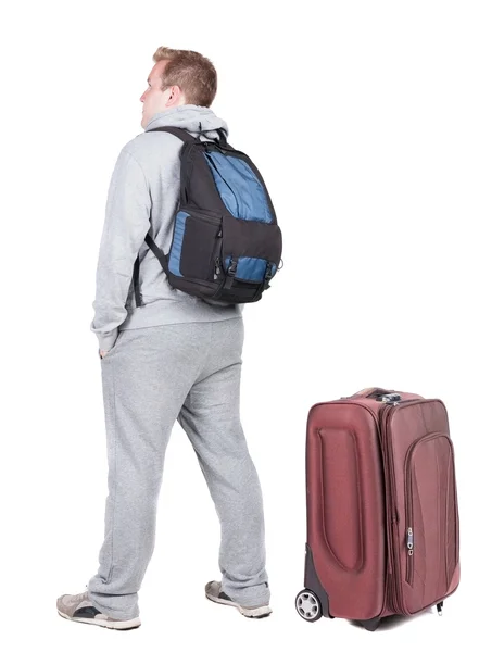 Назад точка зрения молодого человека, путешествующего с чемоданом. — стоковое фото