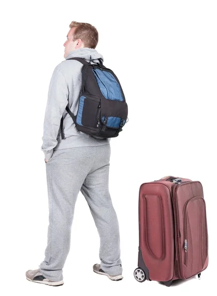 Vue arrière du jeune homme voyageant avec valise. — Photo