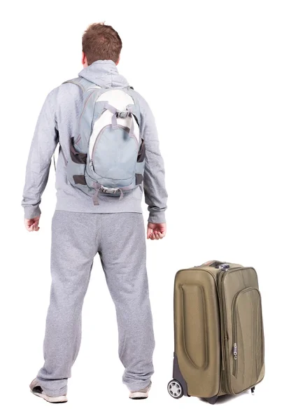 Back view of young man traveling with suitcase. – stockfoto