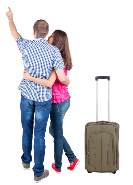 Jonge paar reizen met suitcas en wijzend op de muur — Stockfoto
