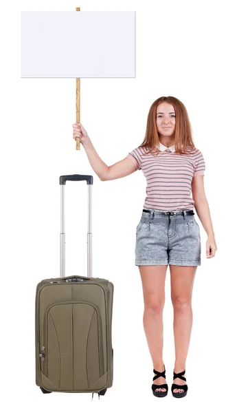 Χαμογελαστό γυναίκα που δείχνει η πινακίδα που ταξιδεύουν με βαλίτσα. — Φωτογραφία Αρχείου