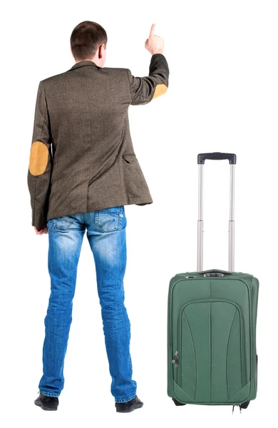 Back view of pointing business man in jacket traveling with suitcase — Stock Photo, Image