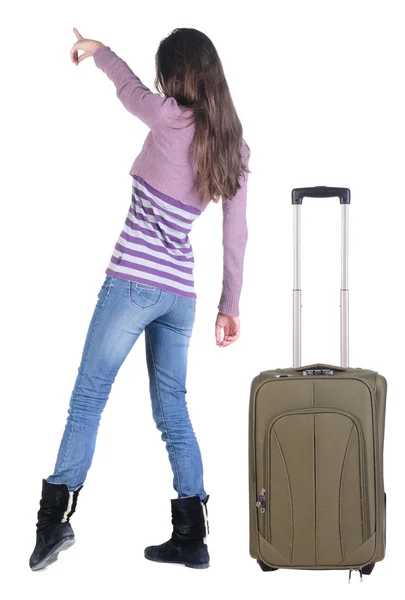 Beautiful young woman traveling with suitcase and pointing at wa — Stock Photo, Image