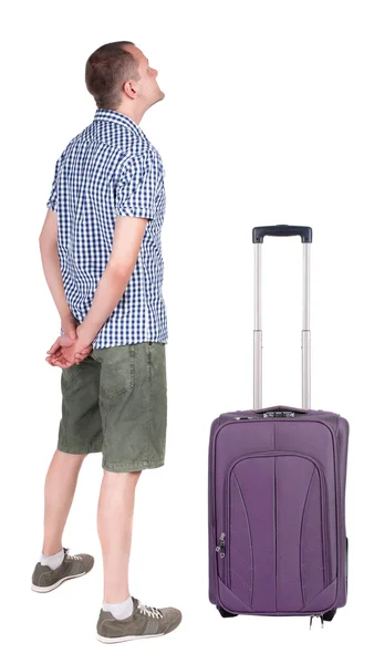 Vue arrière du jeune homme voyageant avec valise. — Photo