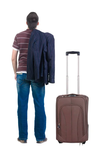 Young man traveling with suitcase looks ahead. Rear view. — Stock Photo, Image