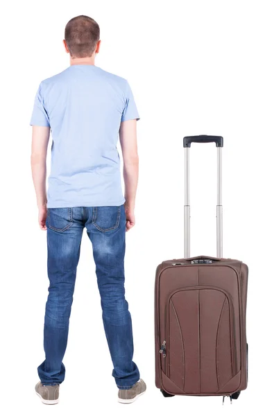 Back view of young man traveling with suitcase. — Stok Foto