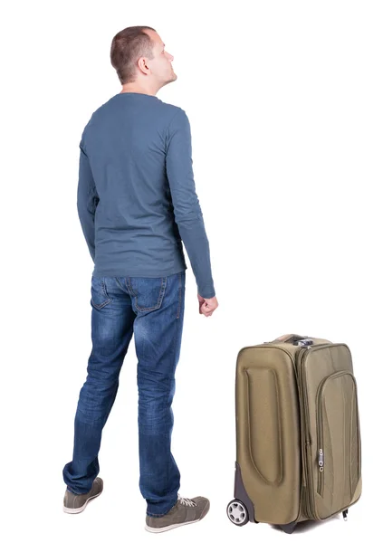 Назад точка зрения молодого человека, путешествующего с чемоданом — стоковое фото