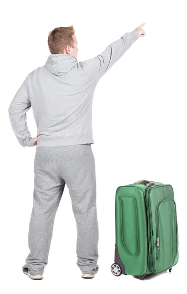 Powrót widok wskazując młodych mężczyzn podróżujących z walizką. — Zdjęcie stockowe