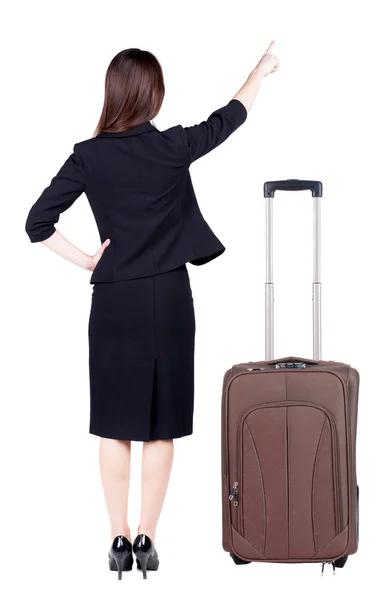 Bakifrån av ung brunett affärskvinna reser med resväska och pekar — Stockfoto