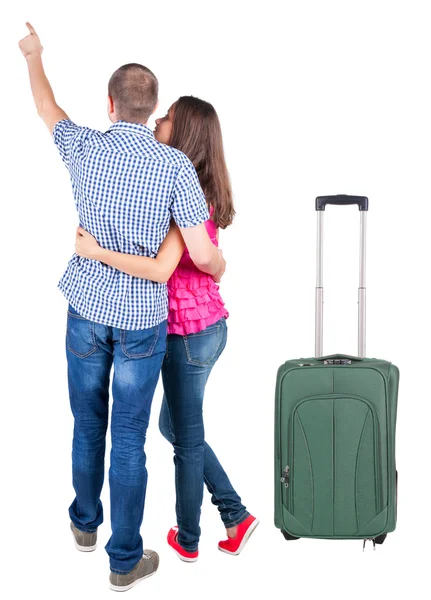 Jonge paar reizen met koffer en wijzend op de muur — Stockfoto